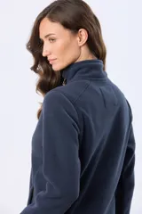 Campera de polar azul marino con cierre frontal completo, cuello alto y bolsillos laterales con cierre. Presenta detalles en cuero en los tiradores de los cierres.