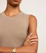 Blusa sin mangas color beige confeccionada en tejido de punto con textura acanalada y cuello redondo.