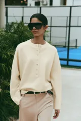 Jersey de punto color marrón, de cuello redondo y manga larga, con cierre frontal parcial de botones.