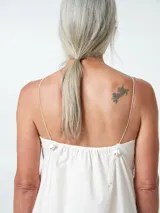 Vestido midi blanco de algodón, con cuello halter y breteles finos ajustables. Corte recto y falda acampanada.