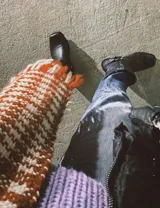 Bota estilo tejana de cuero vacuno color bordó, con detalle de argolla metálica y remaches decorativos.