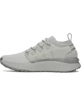 Championes Under Armour Phantom X de color gris claro, con parte superior de tejido transpirable, estructura de TPU translúcido en el mediopié con el logo de la marca, y entresuela amortiguada con suela texturizada para mayor tracción.