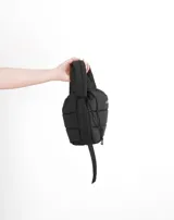 Bandolera azul acolchada con correa ajustable y asa de mano.