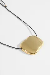 Collar con cordón negro ajustable y dije central de acero quirúrgico con forma orgánica y acabado pulido brillante.
