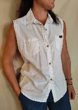 Musculosa tipo camisa con cuello camisero, cierre frontal de botones y dos bolsillos delanteros en el pecho. Diseño a rayas verticales en tonos celeste y blanco.