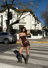 Botas texanas de caña alta color marrón con detalles de tachas doradas. El calzado presenta un diseño con puntera en punta y un pequeño taco cuadrado. Se recomienda pedir un talle más del que se usa habitualmente.