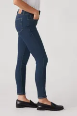 Jean skinny de tiro alto color azul oscuro, con cierre de botón y cremallera, y bolsillos delanteros y traseros.