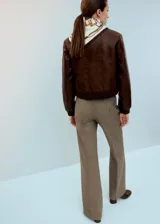 Chaqueta marrón efecto cuero con textura, cierre frontal con botones y puños y cintura elásticos tejidos.