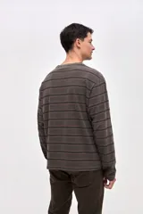 Remera de manga larga con diseño de rayas horizontales en tonos azules. Confeccionada en algodón lavado con textura suave y corte clásico.