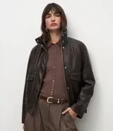 Campera de cuero sintético marrón con efecto desteñido, cuello alto y solapa de piel sintética desmontable. Cuenta con cierre frontal, bolsillos delanteros con solapa y elástico en el ruedo.