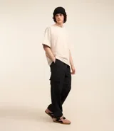 Pantalón cargo de estilo urbano, confeccionado en tejido técnico paper touch. Presenta diseño convertible que permite transformarlo en bermuda, cintura elástica con cordón de ajuste, bolsillos laterales tipo cargo y tiradores en los tobillos para ajustar el ruedo.