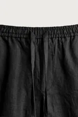 Pantalón relaxed fit de lino color negro, con cintura elástica ajustable con cordón y bolsillos frontales.