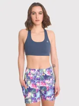 Top deportivo azul con espalda racerback y logo estampado en el frente. Cuenta con almohadillas removibles y sujetador integrado. Ideal para actividades de medio impacto.