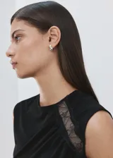 Top negro sin mangas de cuello redondo, con diseño drapeado en el delantero y detalles de encaje en el hombro y lateral.