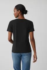 Remera negra de manga corta y cuello redondo, con estampado frontal en forma de estrella que incluye la frase 'Born under a lucky star' decorada con strass.