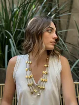 Collar dorado de tres hilos con cuentas circulares.