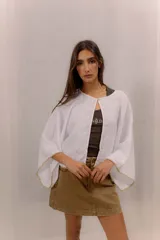 Blusa de lino color blanco, de diseño amplio con mangas murciélago y bordado decorativo en los bordes.