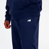 Pantalón de jogging New Balance en color azul marino, confeccionado en tejido French Terry, con cintura elástica, puños en los tobillos y logo de la marca bordado en la pierna.