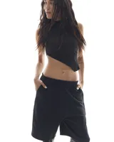 Top negro sin mangas con corte asimétrico.