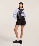 Short sastre negro de cintura alta, corte recto, con pinzas delanteras y trabillas.