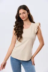 Remera de algodón azul melange con escote redondo y mangas cortas adornadas con doble volado de broderie en los hombros.