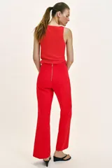 Pantalón de tiro alto en color negro, con diseño de corte recto y ligeramente acampanado. Presenta costuras verticales marcadas en el frente y bolsillos laterales de vivo.