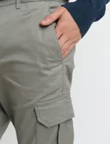 Pantalon cargo de corte ajustado en color verde grisáceo, con bolsillos laterales con solapa y puños elásticos en los tobillos.