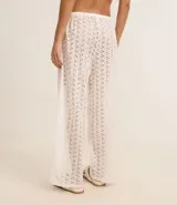 Pantalón de playa blanco con bordado calado tipo laise, cintura elastizada con cordón ajustable y corte recto.