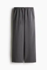Pantalón de corte holgado confeccionado en sarga color gris con diseño de rayas diplomáticas finas. Cuenta con cintura elástica con cordón de ajuste y piernas rectas.