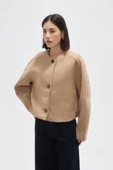 Tapado corto de paño color camel, con cuello redondo, cierre frontal de tres botones y mangas largas con diseño estructurado.
