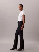 Jeans skinny bootcut de Calvin Klein con lavado clásico oscuro, tiro medio, cierre de botón y cremallera, y diseño clásico de cinco bolsillos.