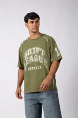 Remera de corte oversize color verde oliva con estampado frontal estilo universitario y detalles de líneas blancas en los hombros y laterales.