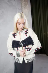 Cardigan de lana tejido y bordado a mano, de calce holgado con cuello a la base, cierre frontal y detalle de flecos en el frente.