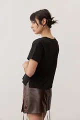 Remera de manga corta color negro, de corte clásico y escote en V, con sutil detalle bordado en el pecho.