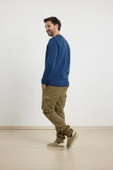 Pantalón cargo negro con bolsillos laterales con fuelle y corte recto.