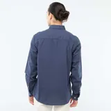 Camisa de manga larga en tejido Oxford, color azul, con cuello abotonado y cierre frontal con botones.