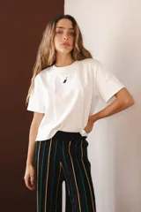 Pantalón negro con rayas verticales en amarillo, verde y rojo. Tejido con elástico en la cintura y lurex.