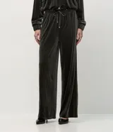 Pantalón de corte recto confeccionado en terciopelo, con cintura elástica ajustable mediante lazo y bolsillos laterales.