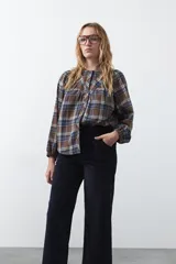 Pantalón de pana color marrón chocolate, de corte recto con bolsillos laterales y cierre frontal.