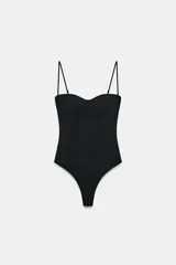 Body negro con escote corazón y tirantes finos ajustables. Presenta un sutil patrón de tejido en relieve vertical y detalle de entredós a tono en el cuerpo. Cierre inferior con botones a presión.