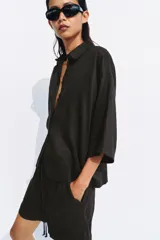 Shorts de tiro medio confeccionados en 100% lino, de color negro. Presentan cintura elástica con volado y cordón ajustable, además de bolsillos delanteros aplicados.