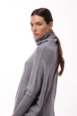 Sweater de punto color gris, con cuello polera amplio y diseño oversize de silueta fluida y caída liviana.