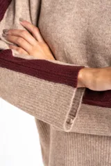 Sweater de tejido de punto con calce oversize, color azul marino con detalles en color marrón en las mangas y cuello. Presenta un diseño de manga larga y puños y ruedo acanalados.