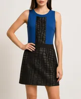 Vestido corto azul con panel central negro texturizado y falda negra acampanada.