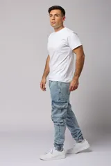 Pantalón jean celeste, corte jogger, con bolsillos cargo laterales y puños elásticos en los tobillos.