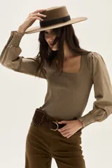 Top de calce al cuerpo con escote cuadrado, confeccionado en tejido de punto acanalado color verde oliva. Mangas largas abullonadas en tejido liso color beige claro, con puños ajustados con elástico.