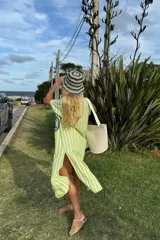 Túnica larga con cuello tipo camisa, de lino a rayas verticales verdes y blancas, con bordado azul en el frente.