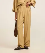 Pantalón recto de tiro alto confeccionado en viscosa, con cintura clochard y detalle de botones frontales. Presenta un diseño fluido y minimalista.