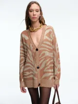 Cardigan de punto con escote en V y cierre frontal de botones. Presenta un diseño estampado de animal print con acabado brillante, mangas largas y corte holgado.