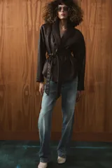 Chaqueta de Zara Woman Collection confeccionada en tejido efecto piel con textura granulada. Presenta cuello solapa, manga larga y cierre frontal con cinturón ajustable mediante lazada. Incluye forro interior.